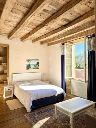 a bedroom with a bed and a large window at La maison de villars in Pressac