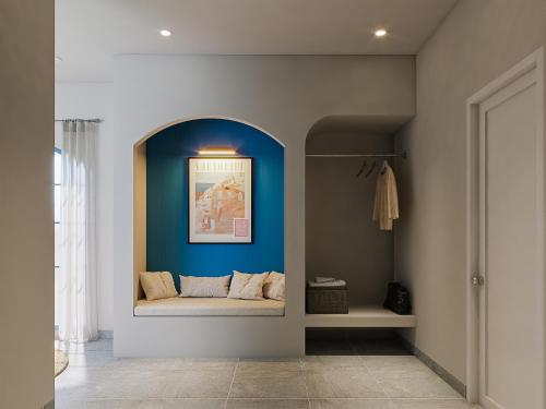 a living room with a couch in a blue wall at TD Santorini Pool Villa in Cổ Lưu (1)