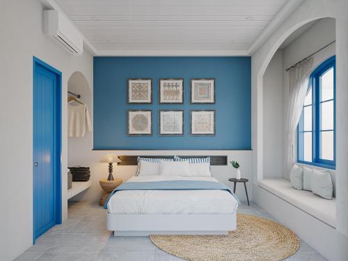 a bedroom with blue walls and a bed with a rug at TD Santorini Pool Villa in Cổ Lưu (1)
