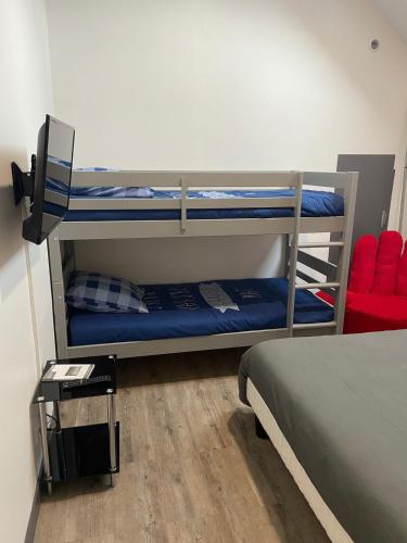 a bedroom with two bunk beds and a red chair at Au Ptit MARIUS in Fécamp
