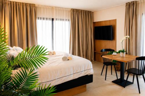 a hotel room with a bed and a table and a desk at Mallorca Suites Playa De Palma in Palma de Mallorca