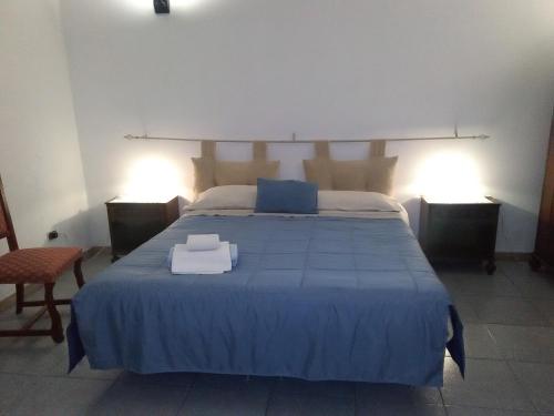 een slaapkamer met een groot blauw bed met 2 verlichting bij B&B Il Tulipano in Taranto