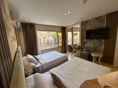 a hotel room with two beds and a window at Grand lotus hotel downtown in Cairo