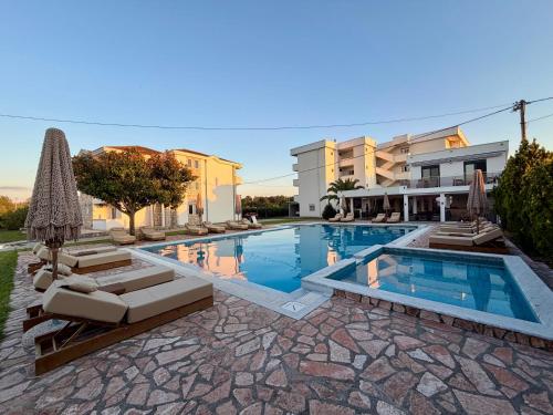 a swimming pool with lounge chairs and a building at Riverside Apartments in Ulcinj