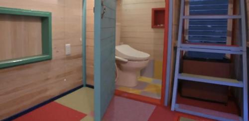 a bathroom with a toilet and a glass door at パワースポットキャンプ場 in Shimoda