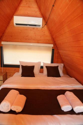 ein großes Bett in einem Holzzimmer mit einer Decke in der Unterkunft Arpa Nest in Areni
