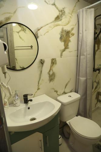 ein Badezimmer mit Waschbecken, Toilette und Spiegel in der Unterkunft Arpa Nest in Areni