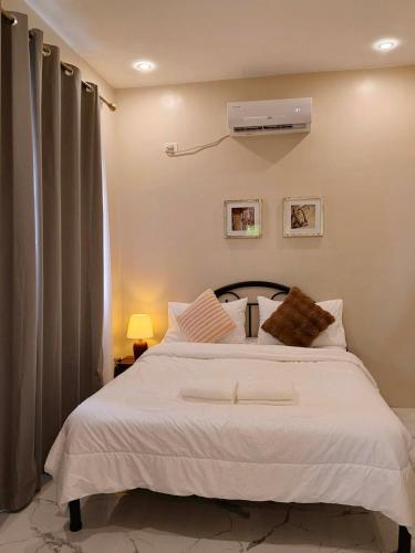 a bedroom with a white bed and a air conditioner at Strand 