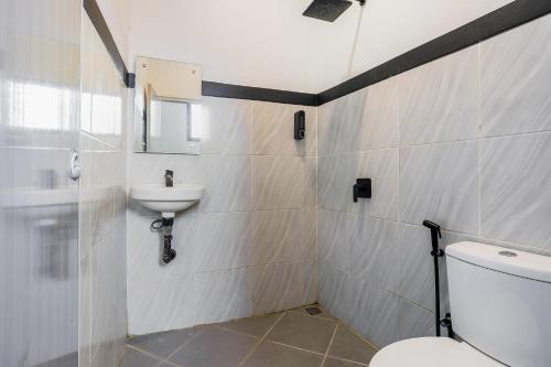 a bathroom with a toilet and a sink at Urbanview Hotel Aloevera Pontianak by RedDoorz in Pontianak