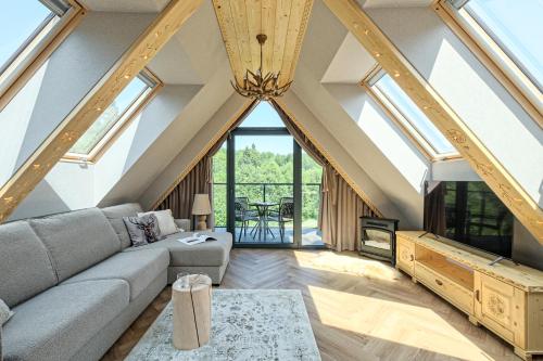 a living room with a vaulted ceiling with skylights at Black Mountain Residence & SPA, Odkryj-Białkę in Białka Tatrzańska