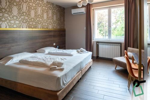 a bedroom with a large bed and a chair at Hotiday Verona Fiera in Verona
