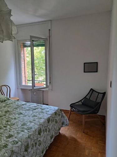 ein Schlafzimmer mit einem Bett, einem Stuhl und einem Fenster in der Unterkunft Agrippa 24 in Mailand
