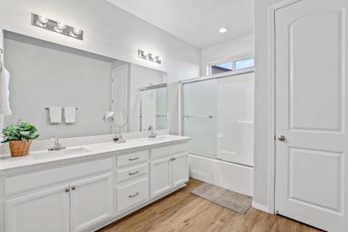 a white bathroom with two sinks and a shower at Grand Canyon Getaway Near Snowbowl Flagstaff Sedona Family-Friendly Sleeps 14 in Bellemont