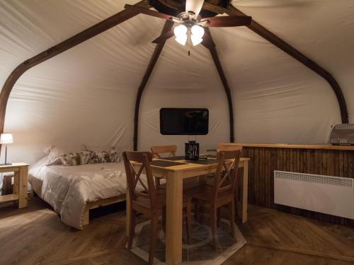 a bedroom with a table and a bed in a tent at Yourtes - Chalets Lanaudière in Rawdon