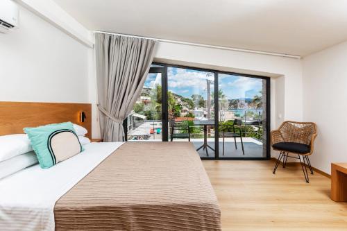 a bedroom with a large bed and a balcony at Petra Suites Tolo in Tolo