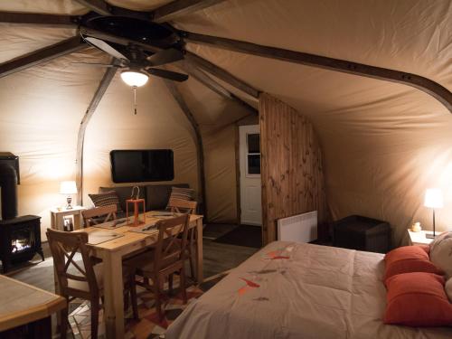 Una habitación con una cama y una mesa en una tienda de campaña en Yourtes - Chalets Lanaudière en Rawdon