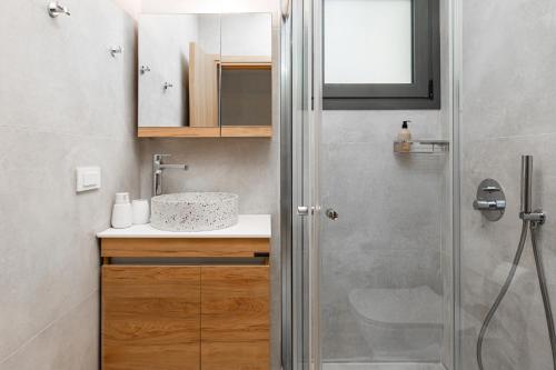 a bathroom with a shower and a sink at Petra Suites Tolo in Tolo