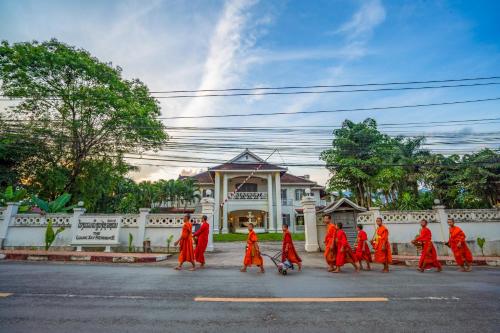 a group of people walking down the street at The Luang Say Residence in Luang Prabang