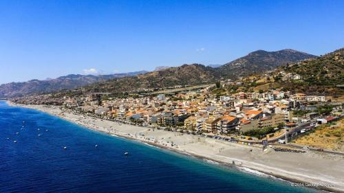 an aerial view of a beach with buildings and the ocean at La Terrazza Bella Sicula in Furci Siculo