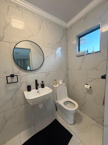 a white bathroom with a sink and a toilet at Cambridge Boutique Stay in Chiselhurst
