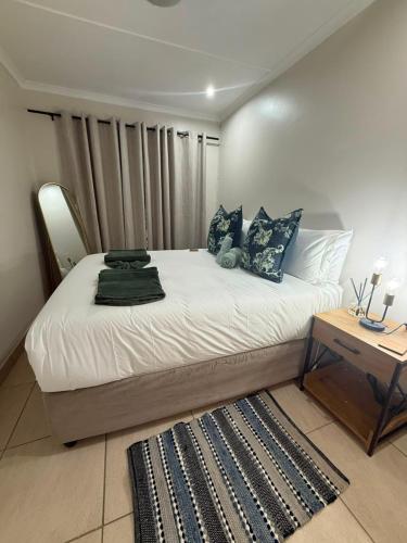 a bedroom with a large bed with a wooden table at Cambridge Boutique Stay in Chiselhurst