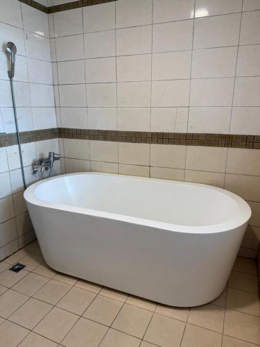 a white bath tub in a tiled bathroom at 一品汽車旅館 in Dounan