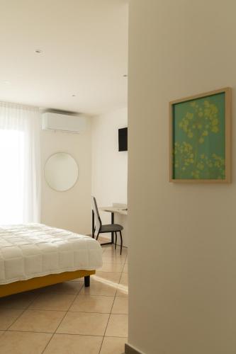 a white room with a bed and a desk at Albergo Sappia in Arma di Taggia
