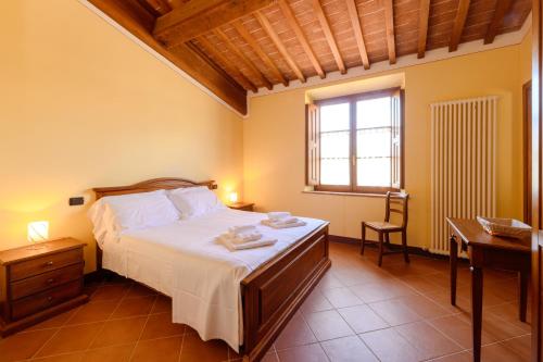 a bedroom with a bed and a desk and a window at Tenuta Santavenere in San Bartolomeo