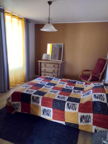 a bedroom with a bed and a dresser and a chair at La loge de la corderie in Marans