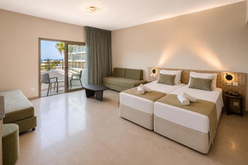 a hotel room with a bed and a living room at Sun Palace Protaras Waterpark Resort in Protaras