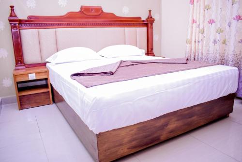 a bed in a bedroom with a wooden headboard at Saphir hotel in Kinshasa
