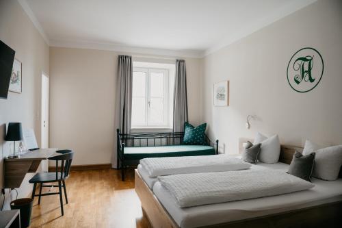 a bedroom with a bed and a window and a couch at Angermühle Landgasthof in Altenmarkt an der Alz