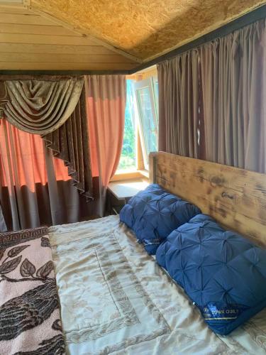 a bedroom with a bed with a wooden head board at Guesthouse Aprasidze in Mestia