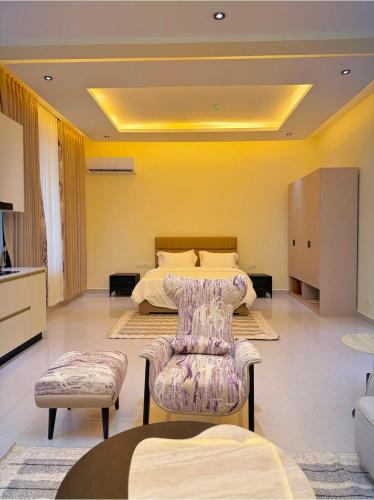 a bedroom with a bed and a couch and a chair at Zabibu Residence in Nkongontha