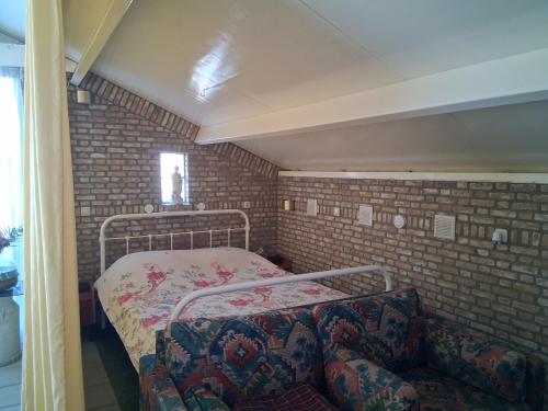 a small room with a bed and a couch at BoerenBuiten De Brakke 1 in Vorstenbosch