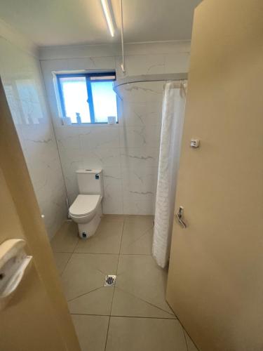 a bathroom with a toilet and a window at Stockman Motor Inn in Narromine