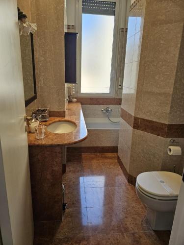 a bathroom with a sink and a toilet and a window at 7 CENTRALE Rooms & Suite in Milan