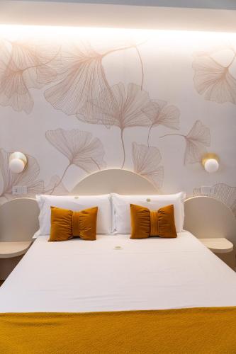 a bedroom with a white bed with orange pillows at DELL'EDERA Luxury Home in Polignano a Mare