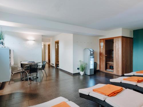 a room with two beds and a dining room at Hotel Bloemfontein in Borkum