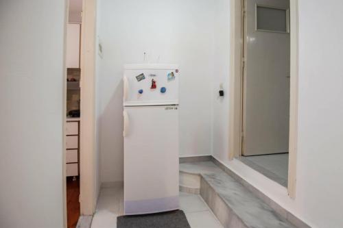 a kitchen with a white refrigerator in a room at Chris' Samos Home in Samos
