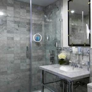 a bathroom with a glass shower and a sink at The Academy - Small Luxury Hotels of the World in London