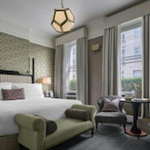 a hotel room with a bed and a chair and window at The Academy - Small Luxury Hotels of the World in London
