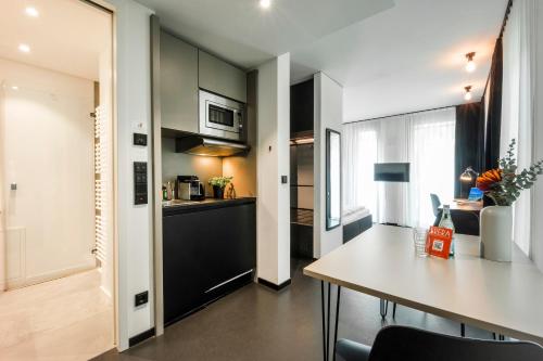 eine Küche und ein Esszimmer mit einem Tisch in einem Zimmer in der Unterkunft Brera Serviced Apartments Munich Schwabing in München
