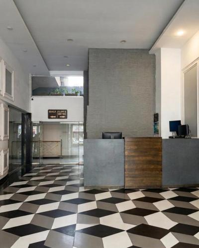 a lobby with a reception desk and a checkered floor at Hamsun Apart Hotel Clifton in Karachi