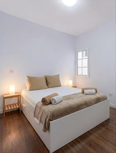 a white bedroom with a large white bed and a window at Sardina Beach Retreat in Gáldar