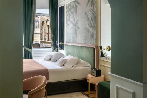a bedroom with a bed with two pillows on it at Hotel La Gemma in Florence