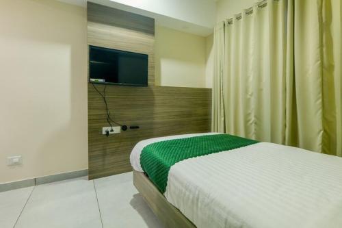 a bedroom with a bed and a flat screen tv at The Heartland Business Hotel in Trivandrum