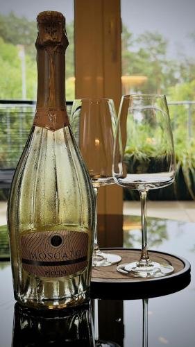 a bottle of wine and two glasses on a table at R&J apartmány in Bojnice