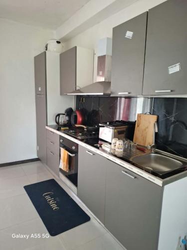 a kitchen with stainless steel appliances and a sink at Villa TSARAJORO in Toamasina