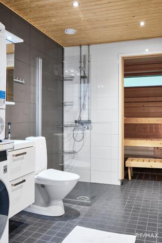 a bathroom with a shower and a toilet and a tub at Modern two-bedroom apartment in Espoo